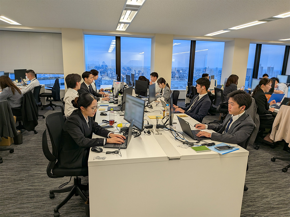オフィスで各自デスクワークをしている社員たちの様子