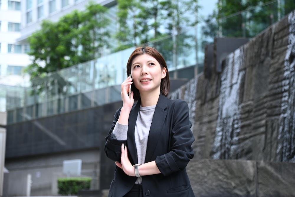 法人営業部の社員が、訪問先でお客様からの電話対応をしている様子